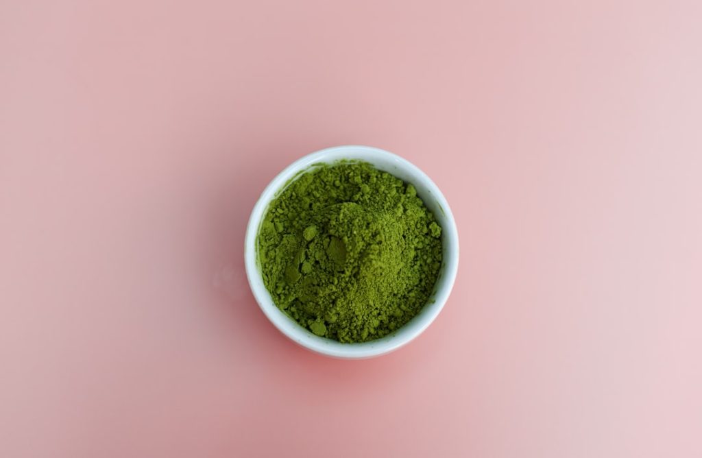 Matcha powder on pastel pink background